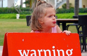 Child holding a warning sign