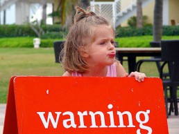 Child holding a warning sign